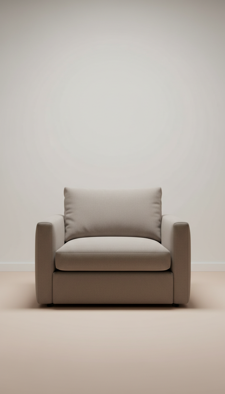 A soft upholstered armchair in a quiet, sunlit room